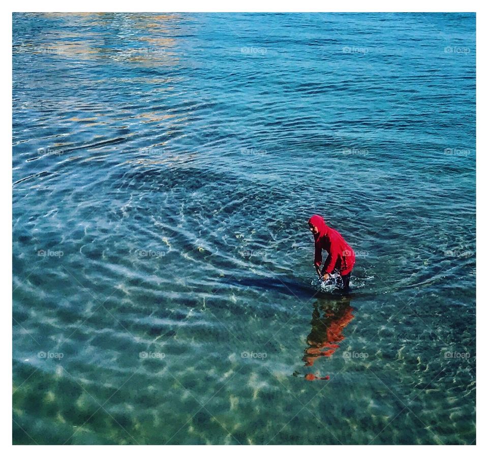 Moroccan woman bathing in the sea dressed in red