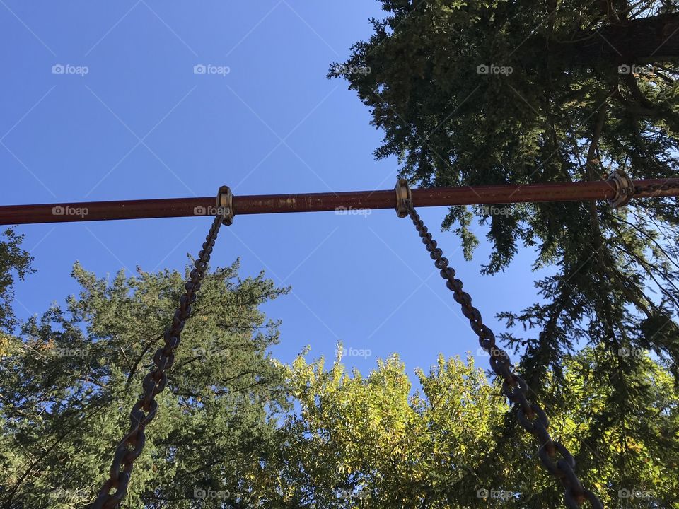 Looking up on a swing into the sky. Watching the chains that hold us down going into the beautiful blue sky reminds me of how we can fly if we leave our minds open to all the options of life.