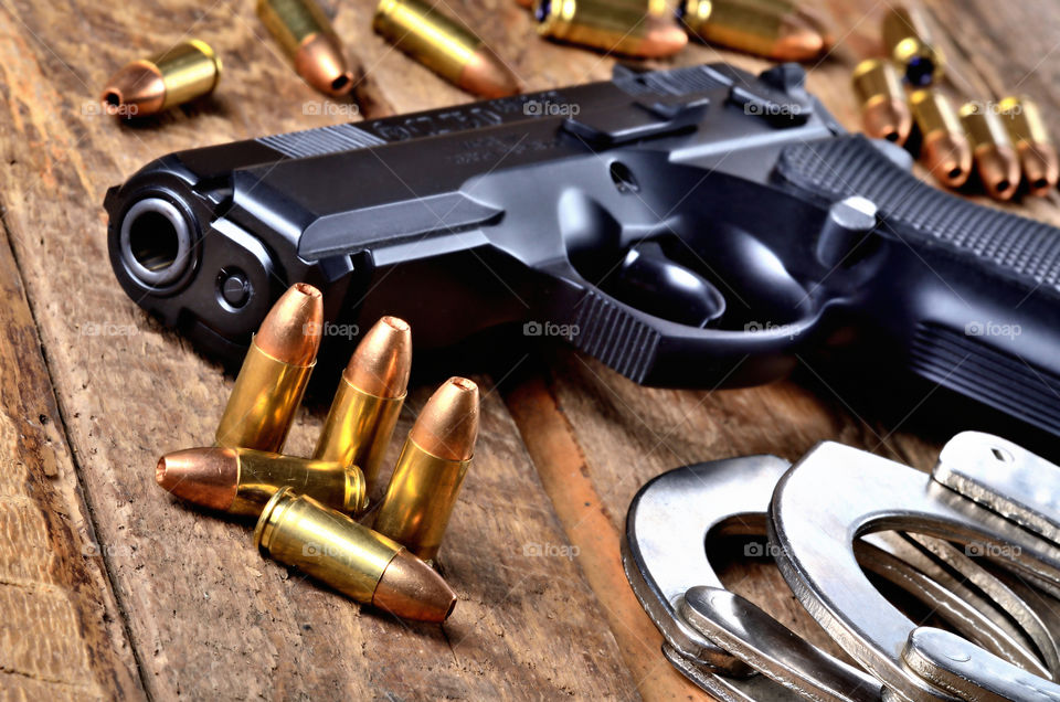 Close-up of 9mm pistol gun, bullets and handcuffs