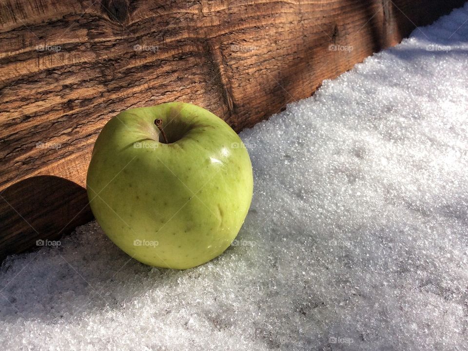 A green Apple on the snow