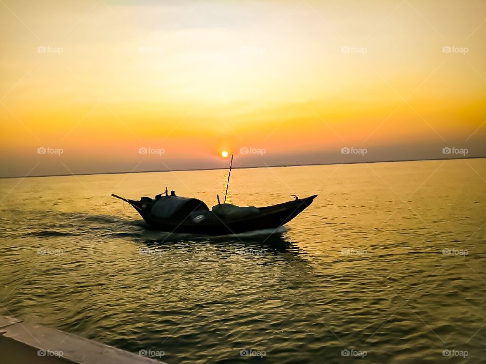 It is a scenery of a  boat that sailed on a sunset time. I had taken the scenery picture on my mobile phone camera while I  had  gone to a trip to Sunderban , West Bengal , India.