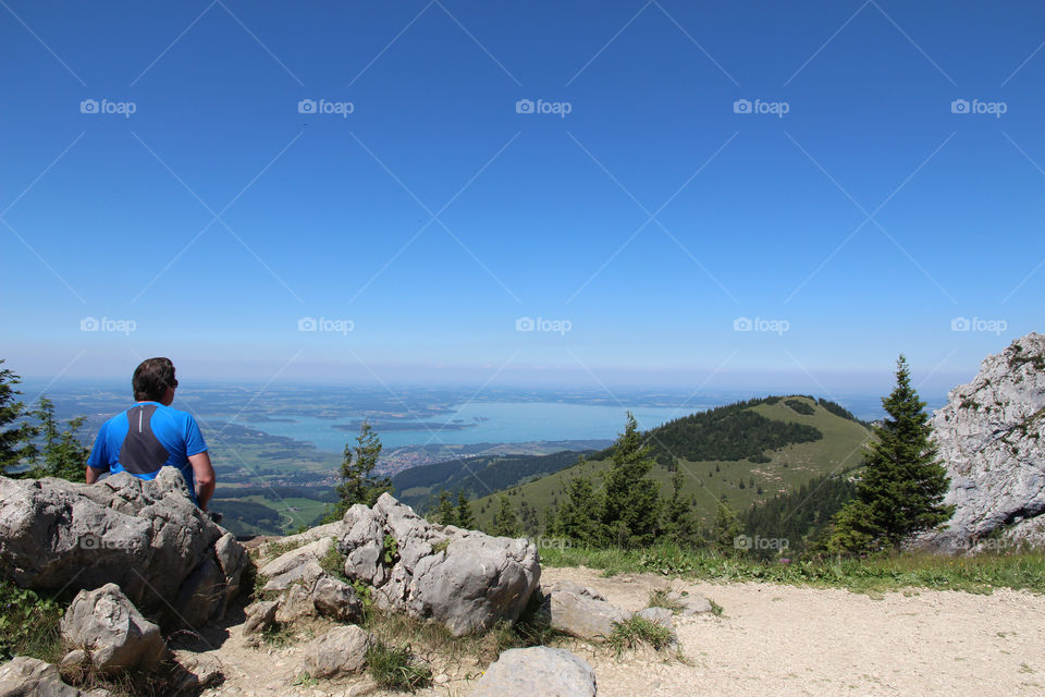 Hiking trail at high altitude, hiker enjoying the view of landscape and lake 