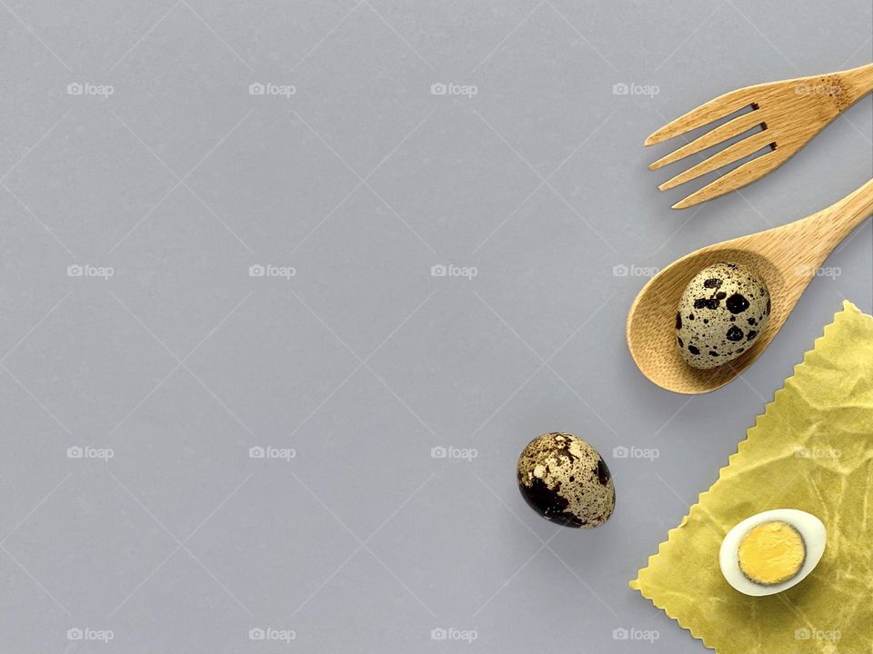 quail eggs on waxed napkin, wooden spoon and fork, Easter concept