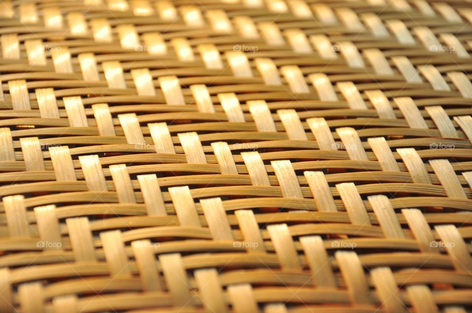 Brown woven bamboo closeup texture. Wicker texture. Winnowing or threshing basket. Woven bamboo pattern. Diagonal pattern texture. Abstract texture.