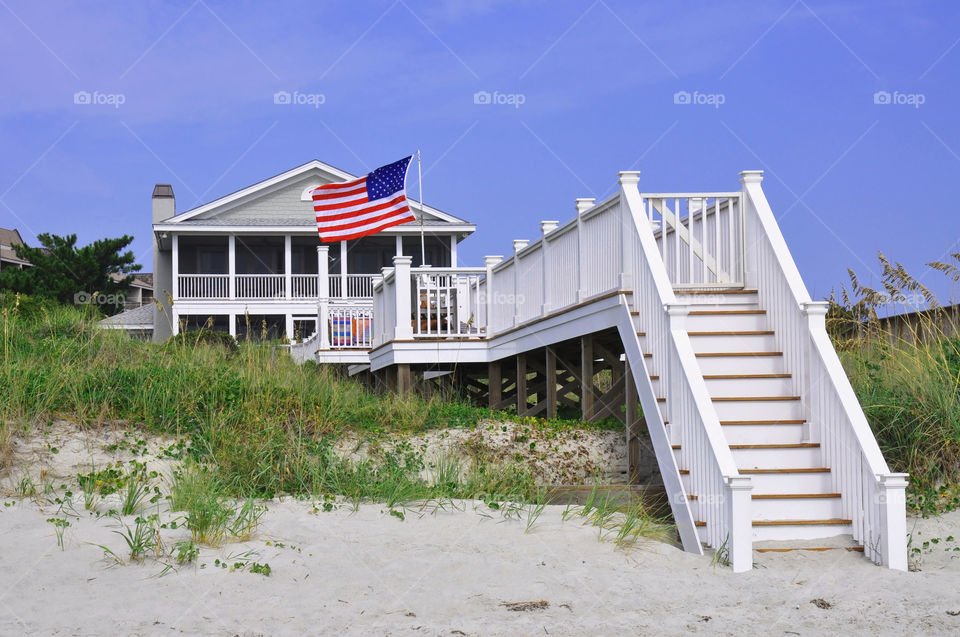 A beautiful beach house proudly flys the American Flag. 