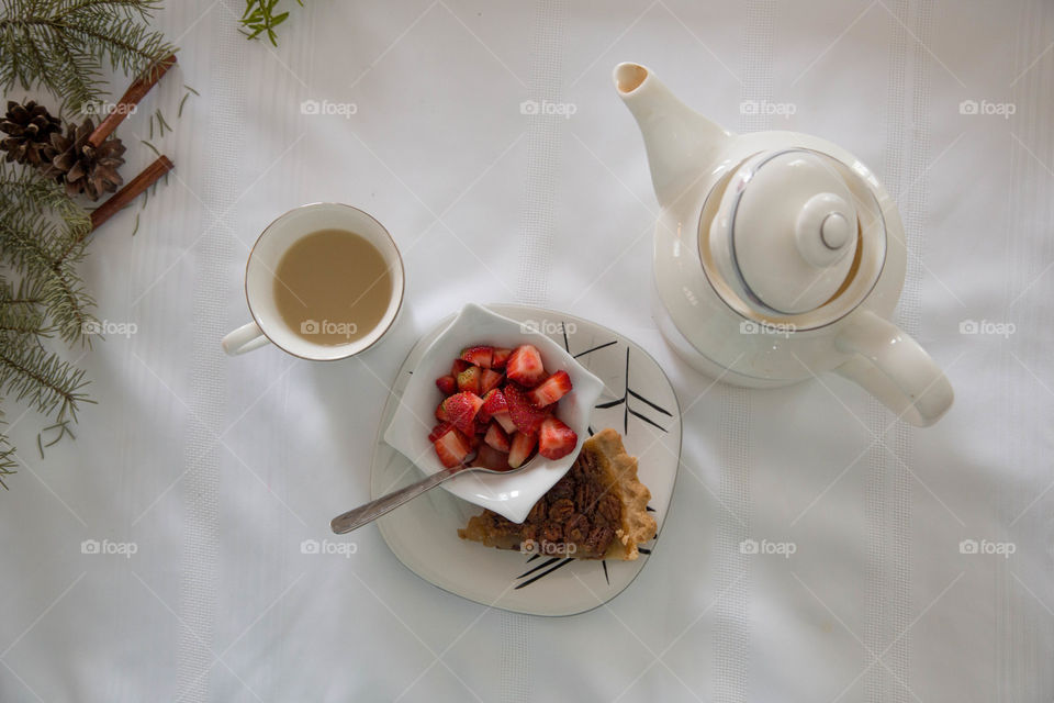 Tea, strawberries and pecan pie in a festive flat lay, beside teapot