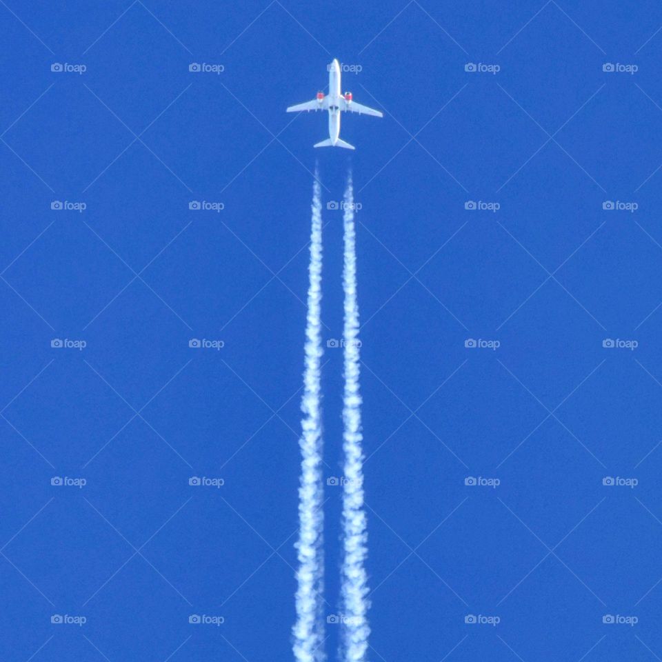 Airplane in blue sky. Vapor trails, Boeing 737 from Scandinavian Airways Systems SAS