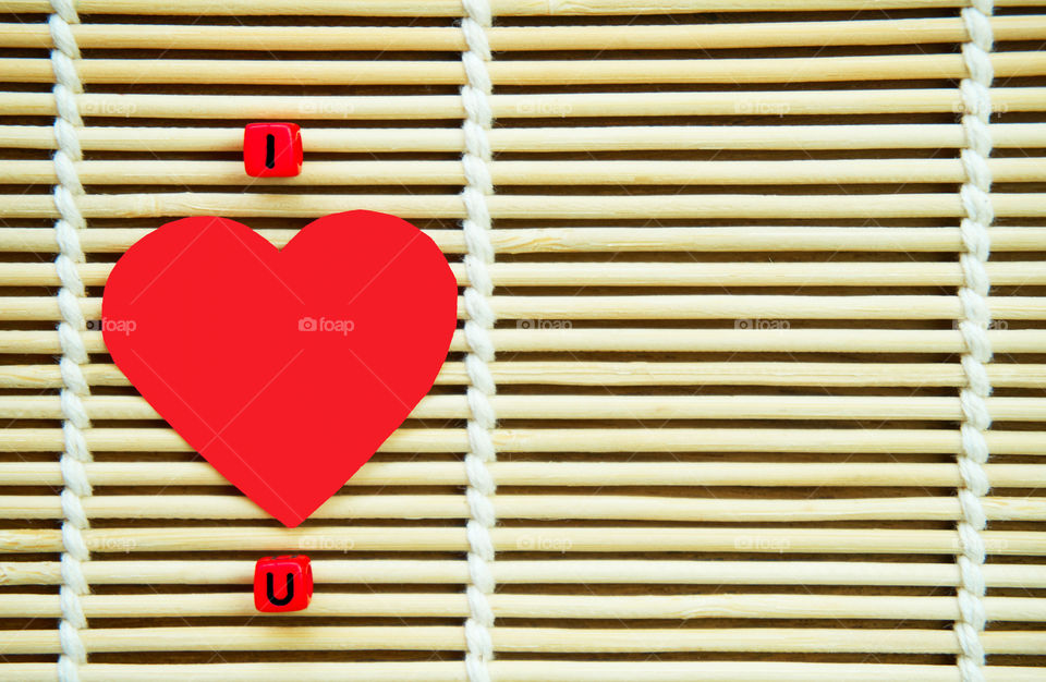 Red heart on bamboo background with copy space 