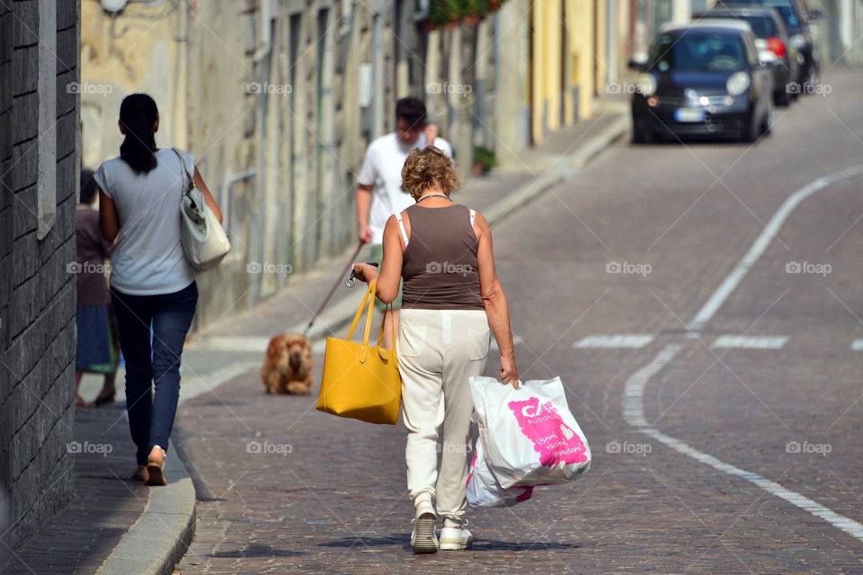 a woman walking on the road after shopping