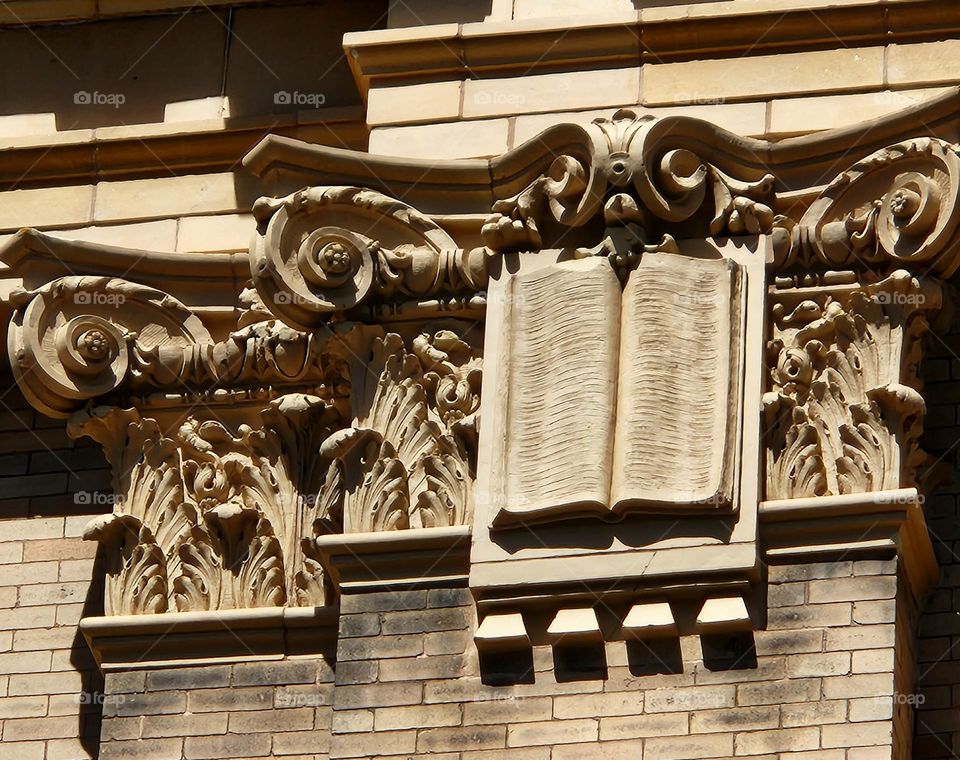 close up view of an ornate book carving on one of the Astoria Courthouse walls in Oregon