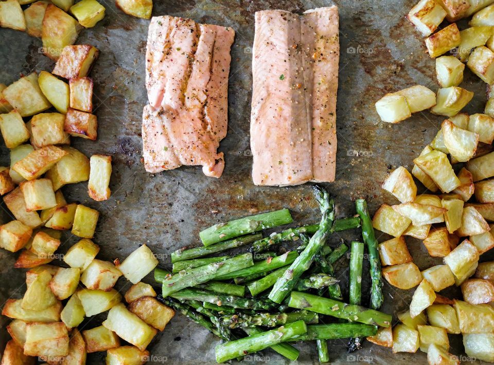 Overhead photo of roasted salmon fillet with asparagus and potatoes on baking tray