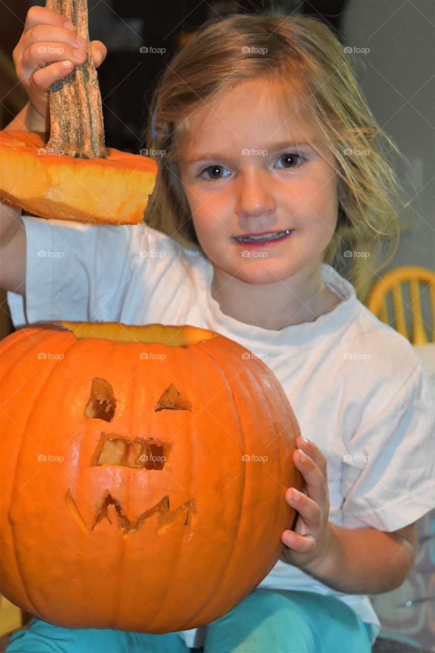 girl proud of her pumpkin carving