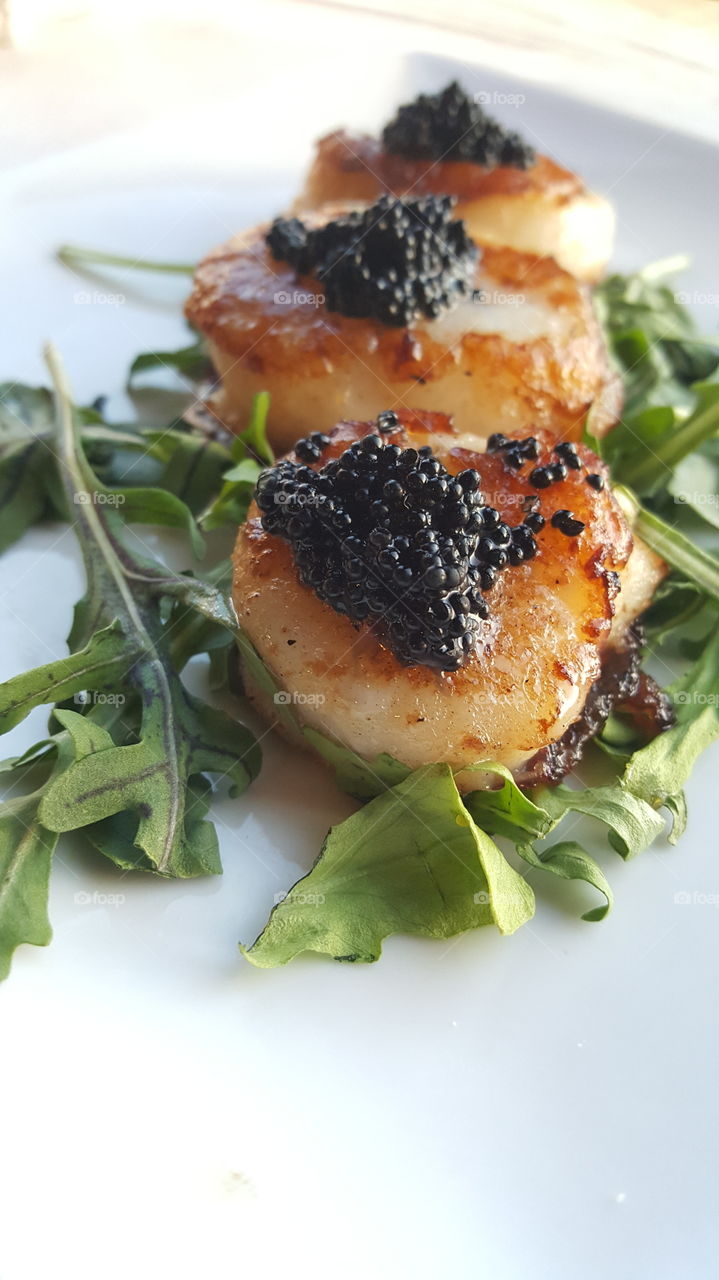 Scallops with Black Caviar on Lettuce - Close Up