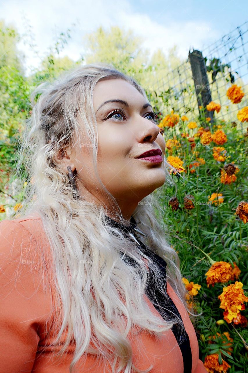 Beautiful woman in Orange with Orange flowers background dreamy fairytale portrait