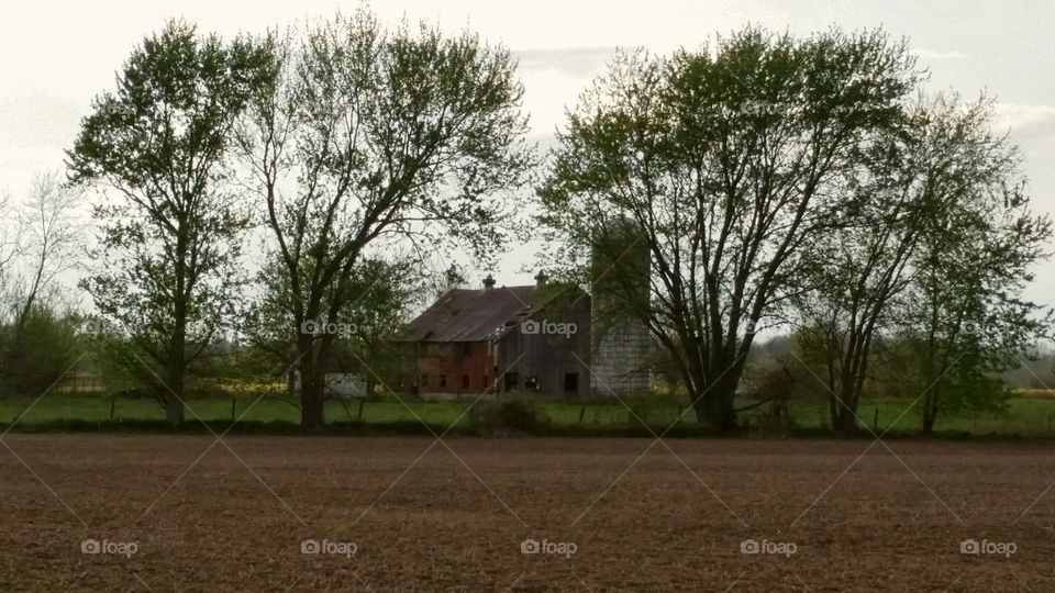 Decayed red barn brown field and silo