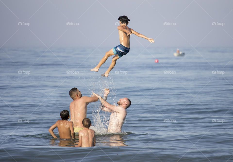 Boys fun, flying boy in the sea
