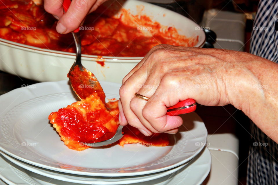 elderly hands serving italian food