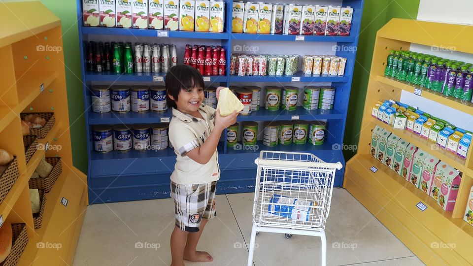 Young boy shopping. kid at supermarket