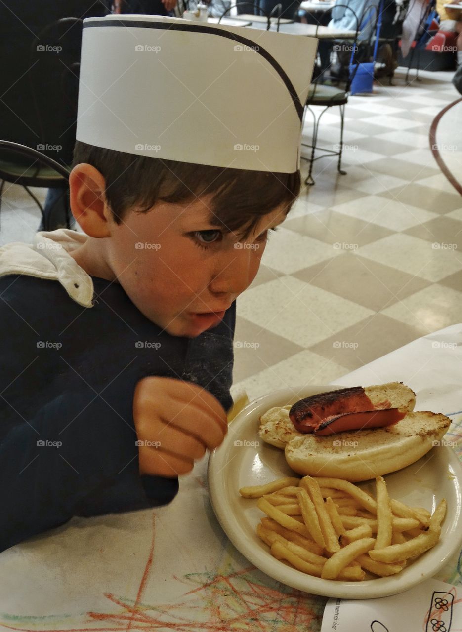 Little Boy Eating A Hotdog