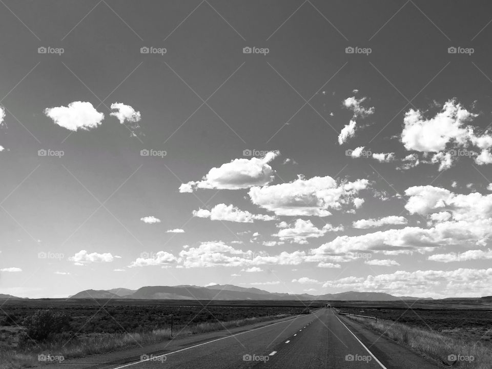 Black and white rural highway with mountains in the distance 