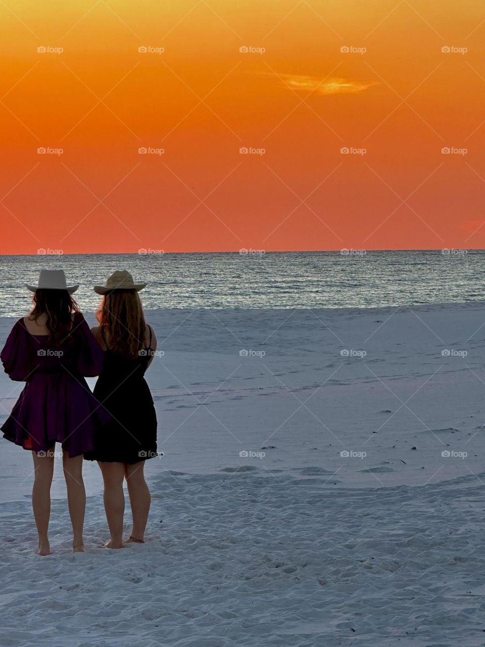 Cowgirls barefooted in the white sand enjoying the January sunsets on the Gulf of Mexico