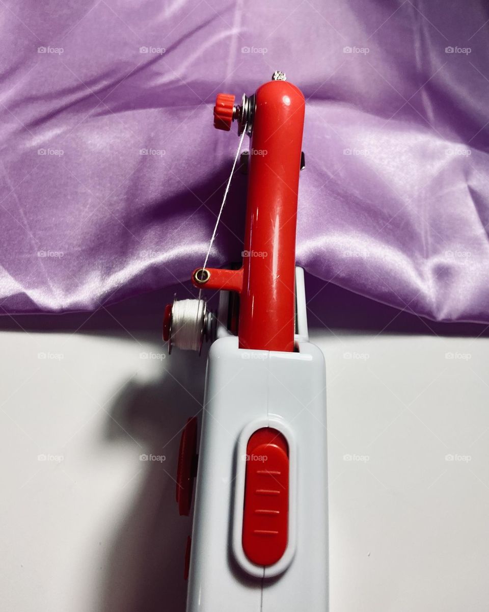 Red handheld Singer sewing machine.