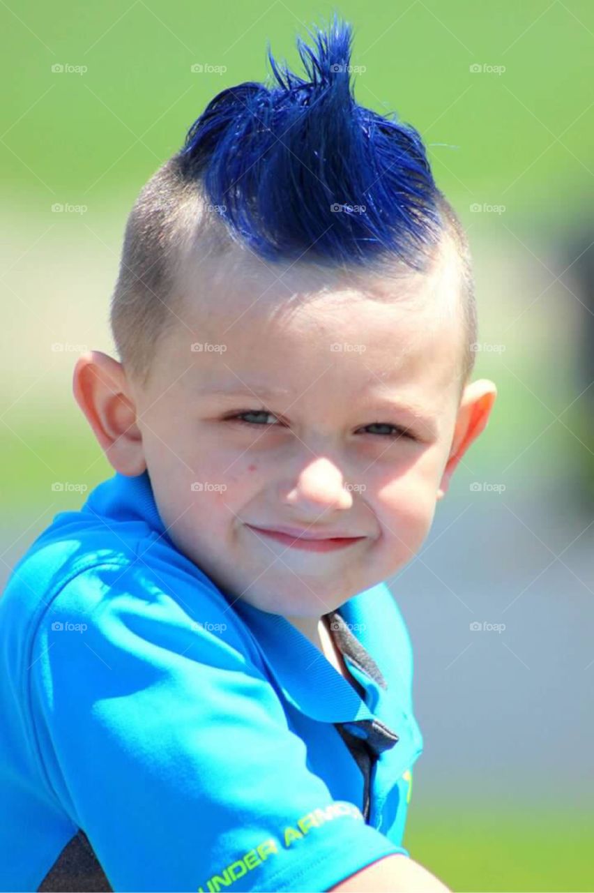 My little blue haired boy with a spiked mohawk squinting as I take his picture on this summer day. 