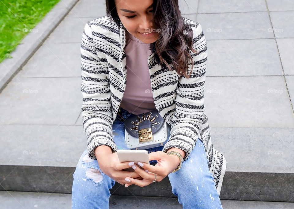 Happy smiling beautiful young woman using smartphone