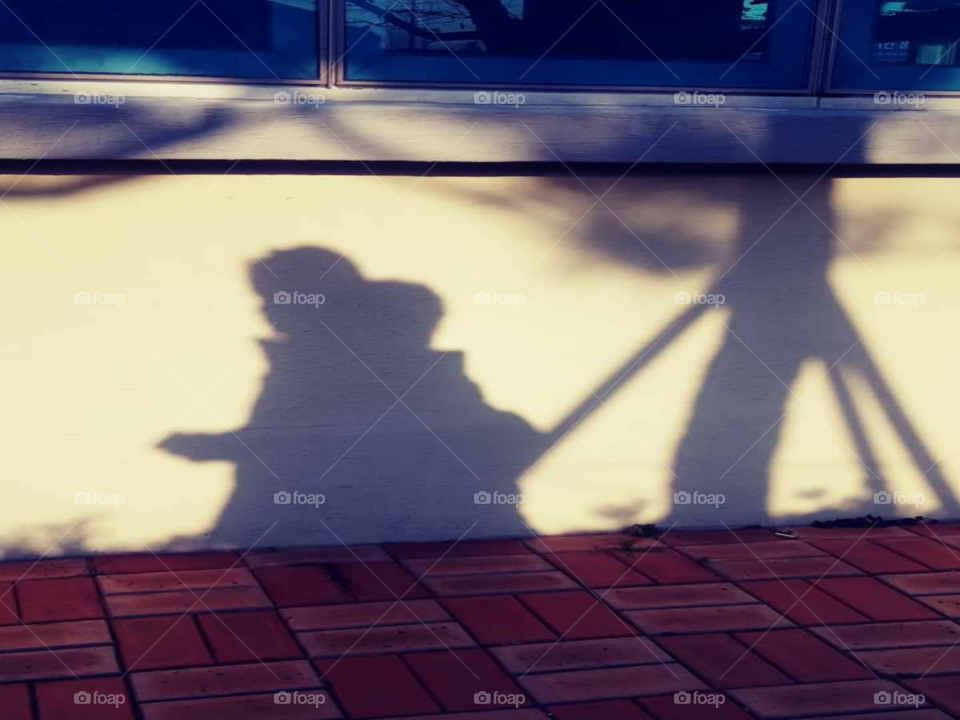 shadow of a child walking around at the back of her mother.