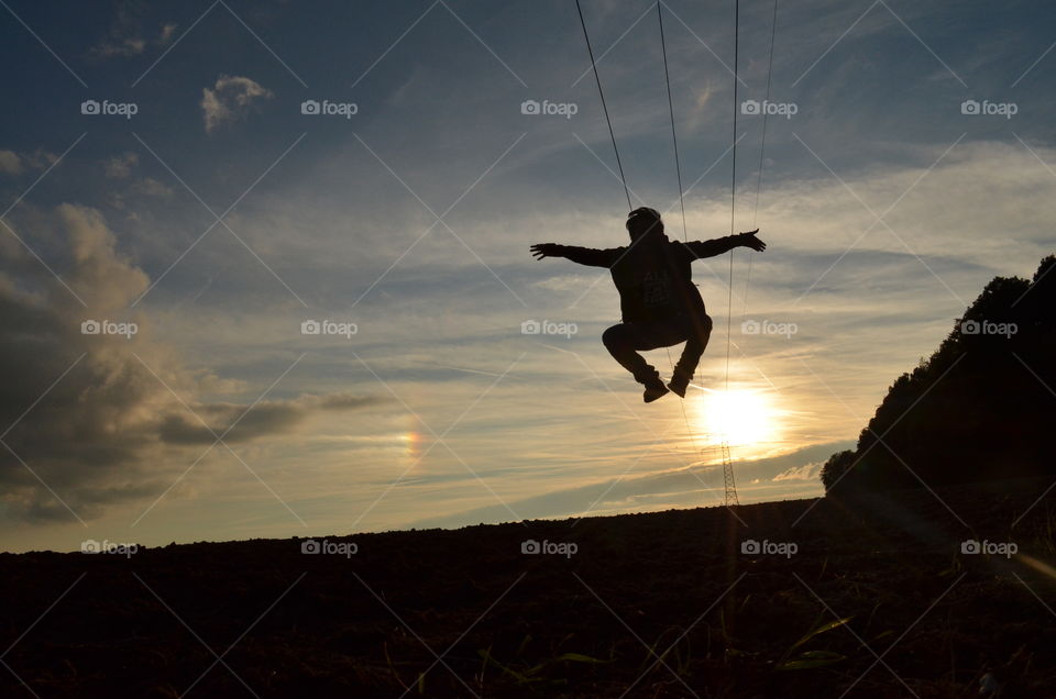 Silhouette of skydiving in mid-air during sunset