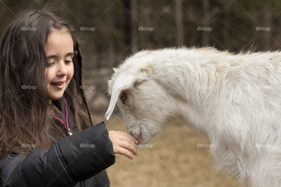 Small child standing with goat