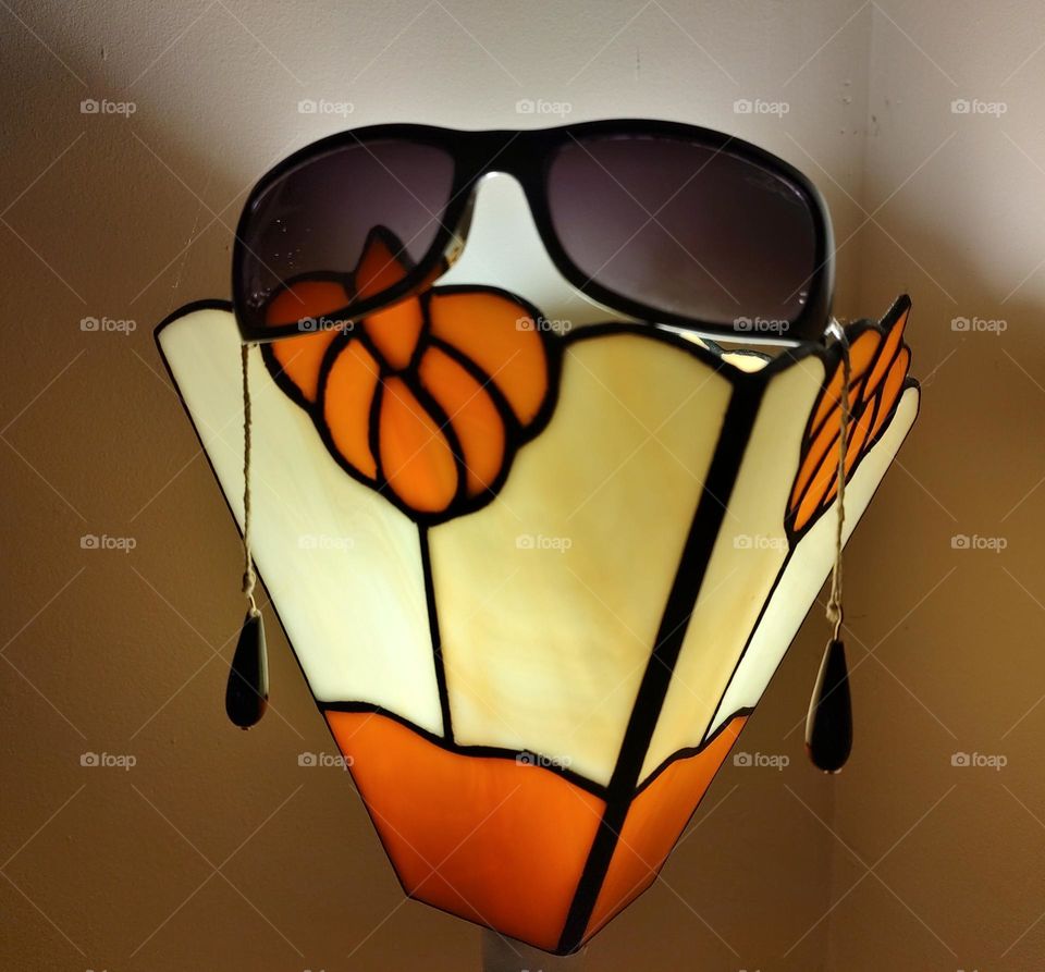 Art Deco lamp with sunglasses resting on the top.