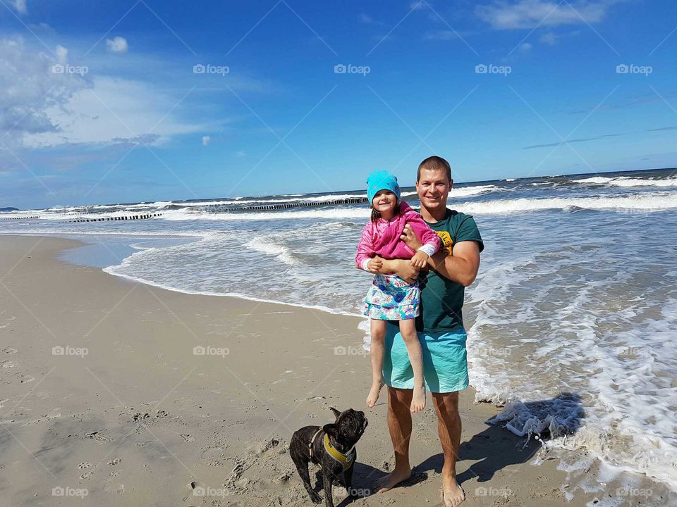 Father and daughter at beach with dog