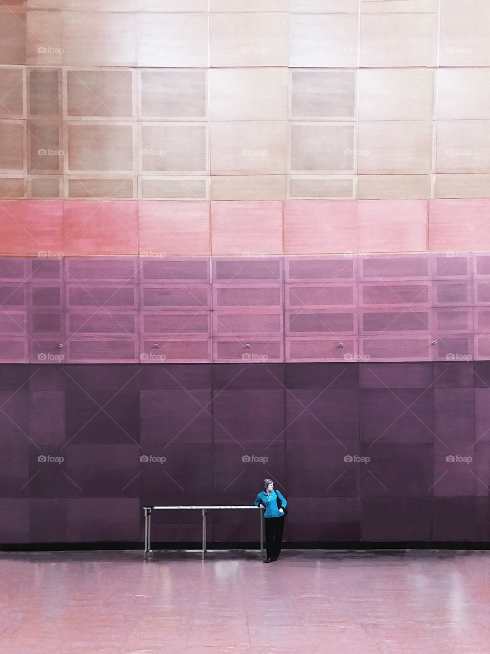 Tiny human in front of a geometric wall 