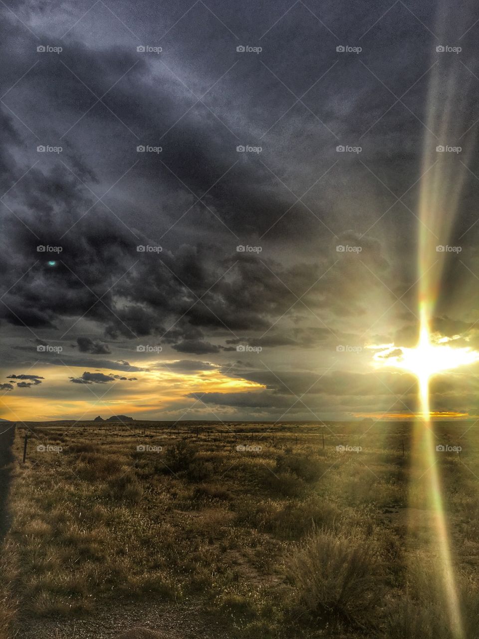 The sun is peeking from behind the clouds around Capitol Reef National Park. 