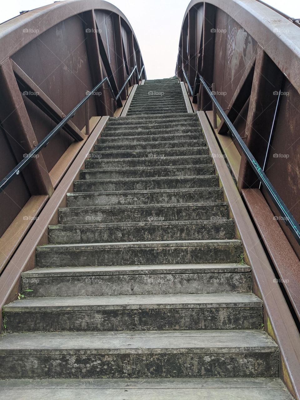 stairs up the rusty rainbow bridge in crescent park new orleans