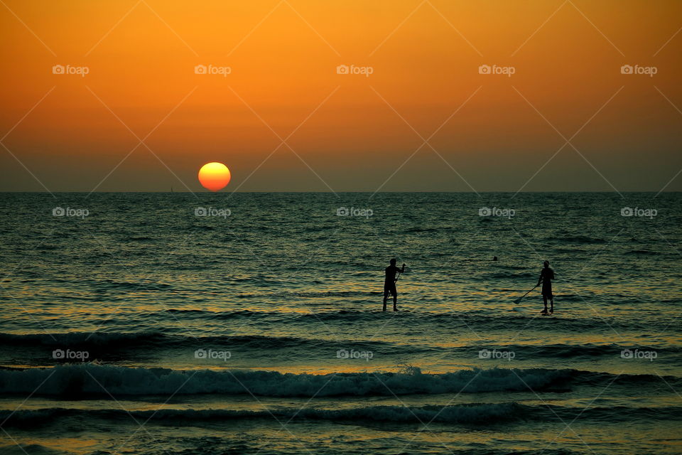 golden hour in the sea. surfing in the beach of tel aviv