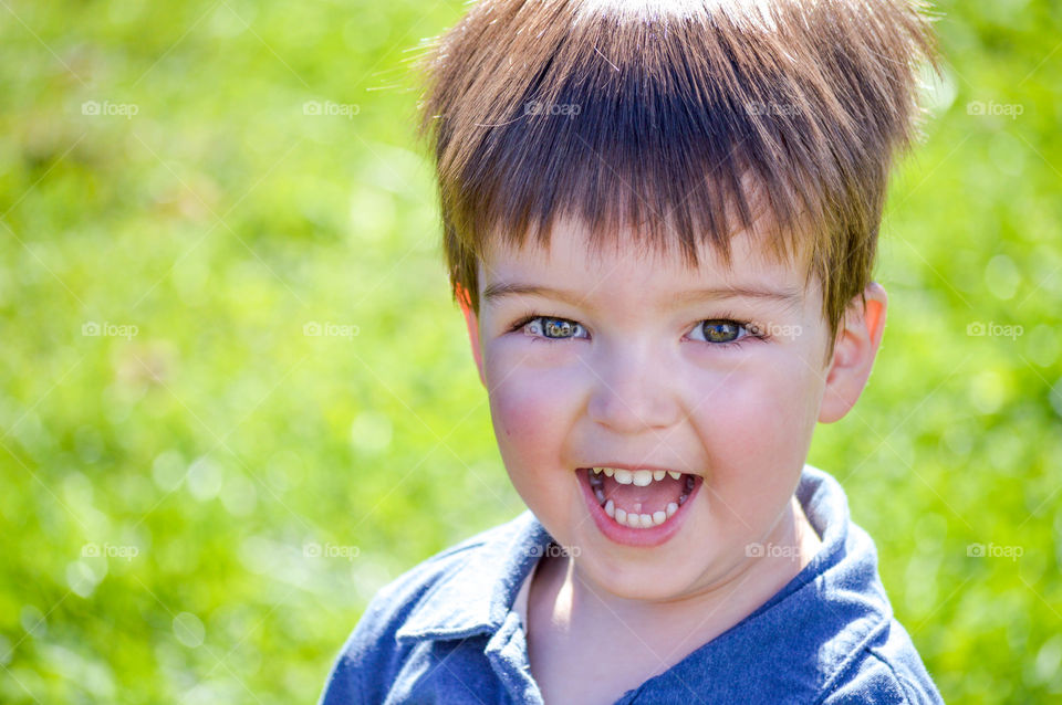 Happy young toddler boy smiling outdoors in the spring