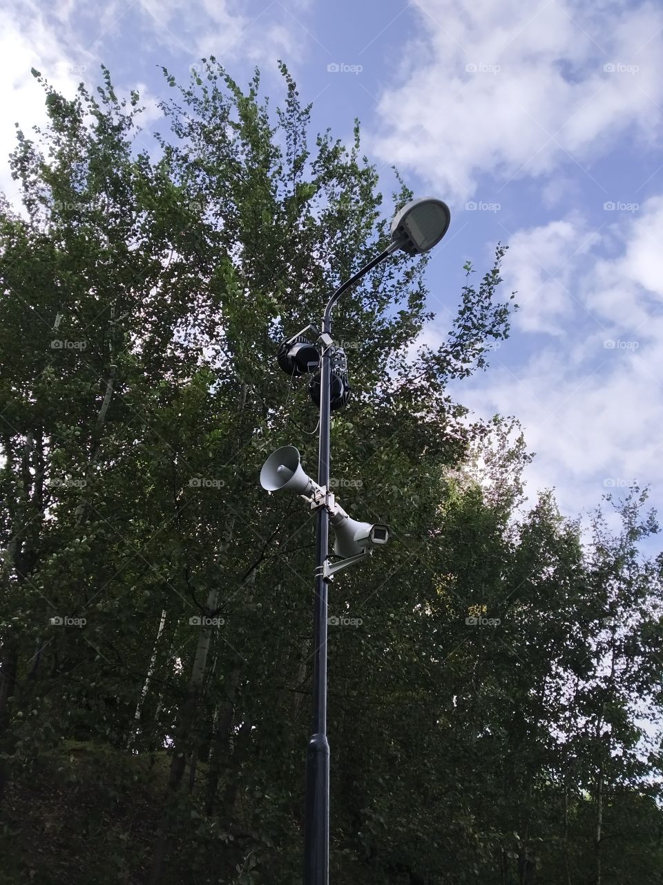A lamppost with a loudspeaker.