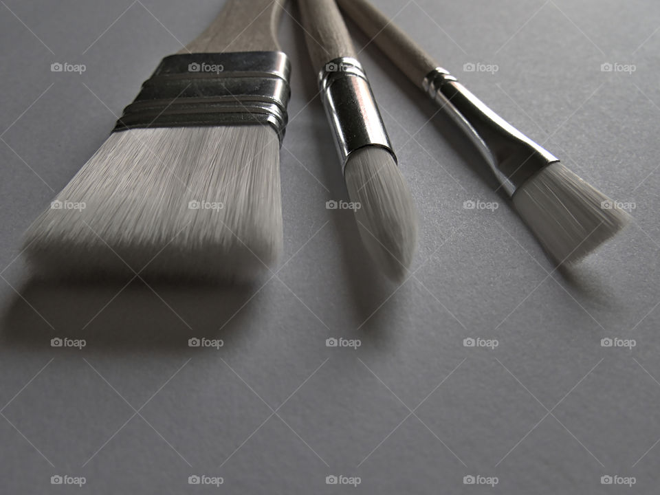 Set of new art brushes on white surface and soft lighting
