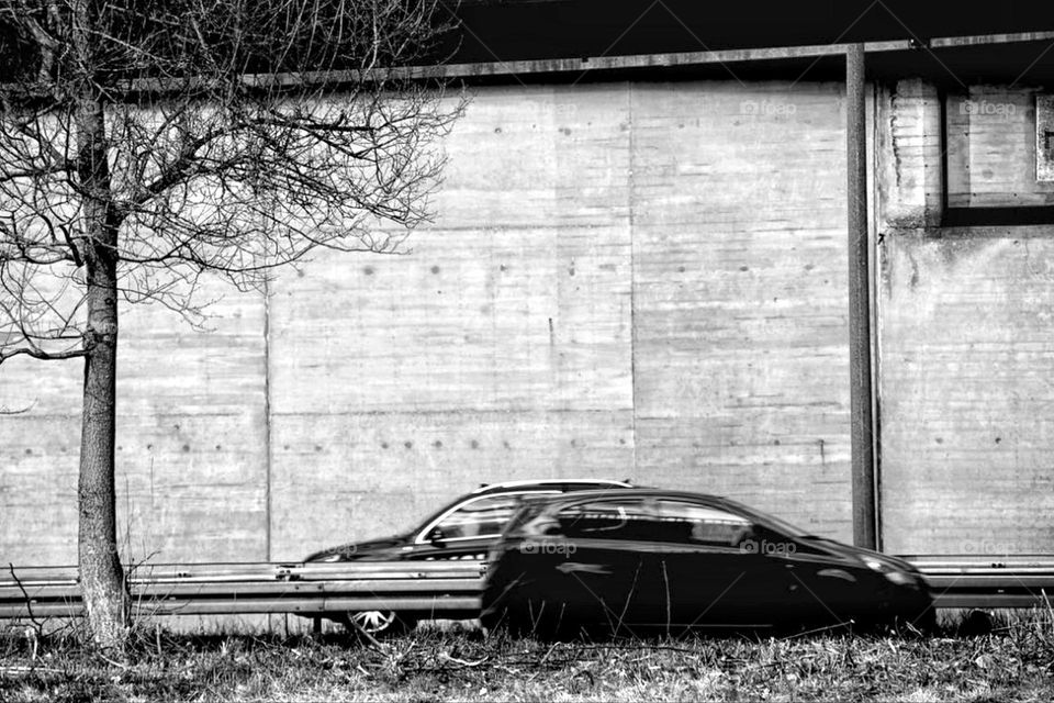 Black and white photo of two cars meeting on the highway