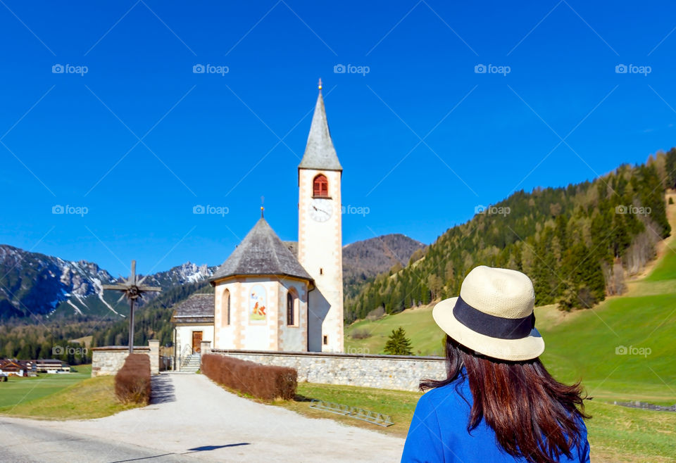 Woman, standing in front of Saint Vito church, South Tyrol, Italy