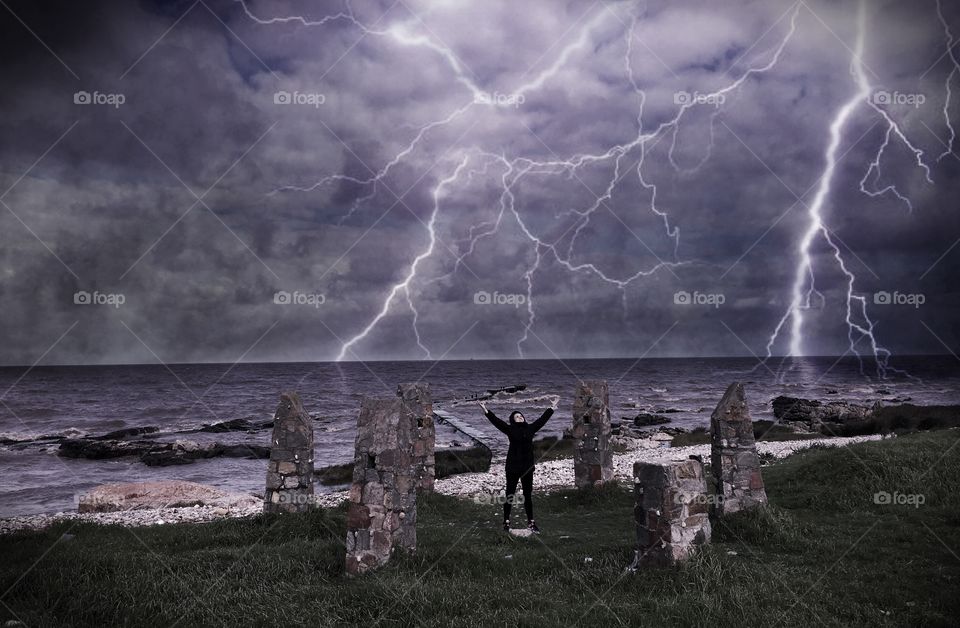 Woman standing at beach raising her hand