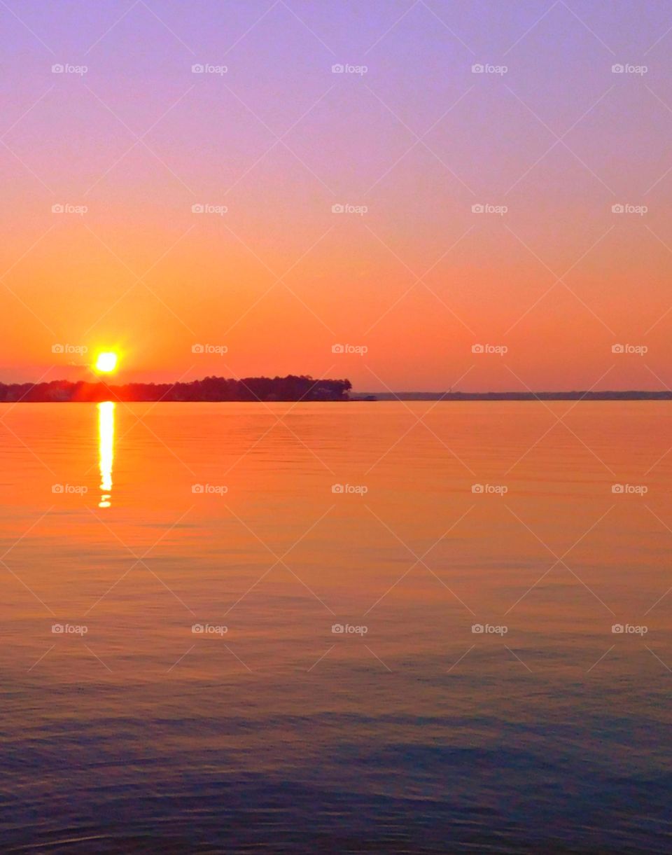 Sunrise - Mesmerizing sunrise over the ocean with mauve colored sky and an orange reflection from the sun on the waters surface