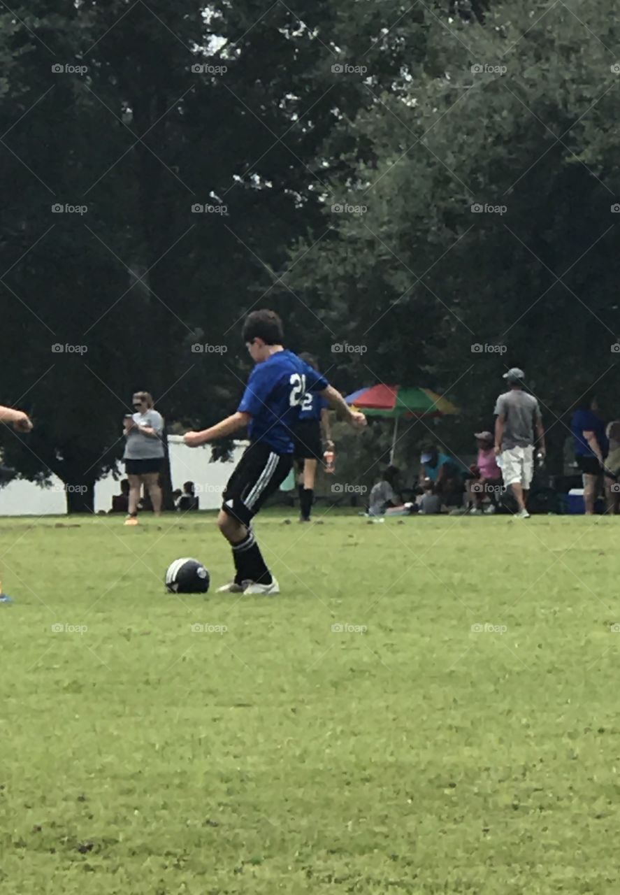 Action shot just before a kick of a young teen boy in a soccer game!!