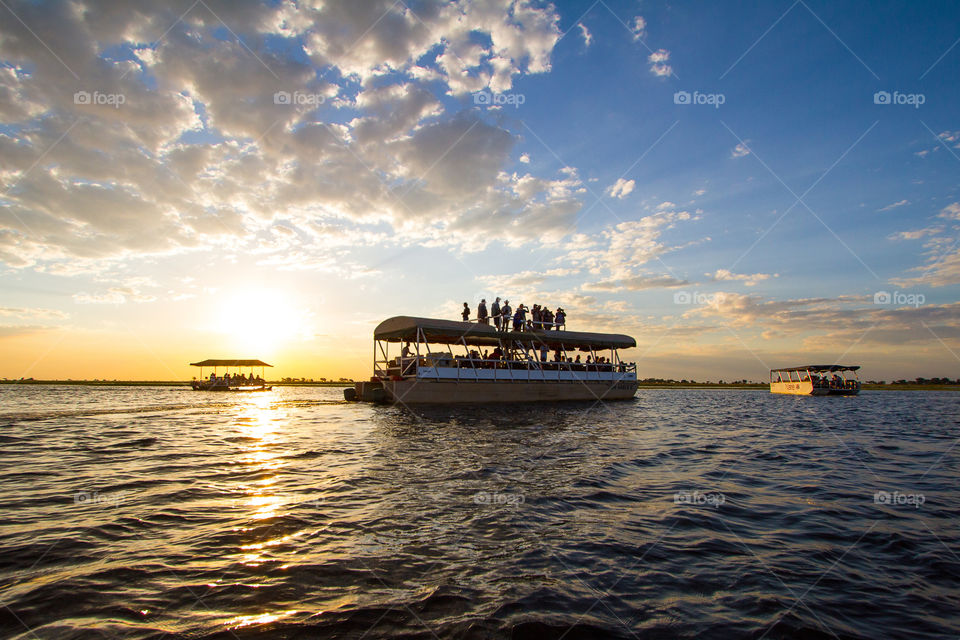River cruises at sunset - image of boats with sun setting over the water