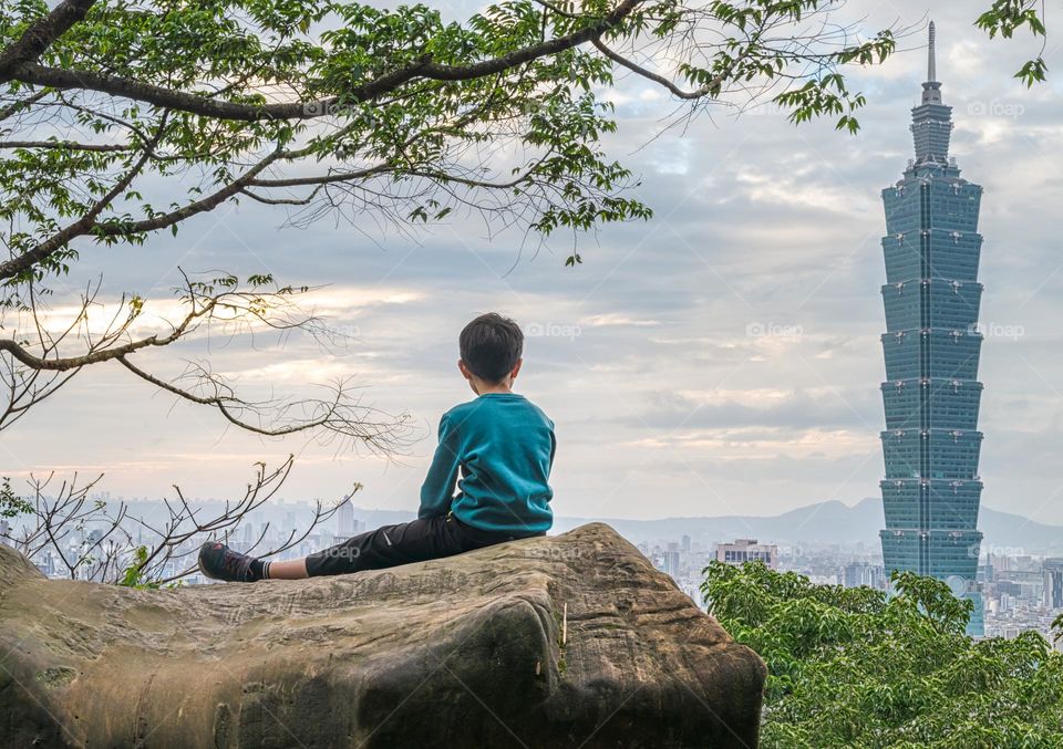 Kid on the big rock to see 101 building