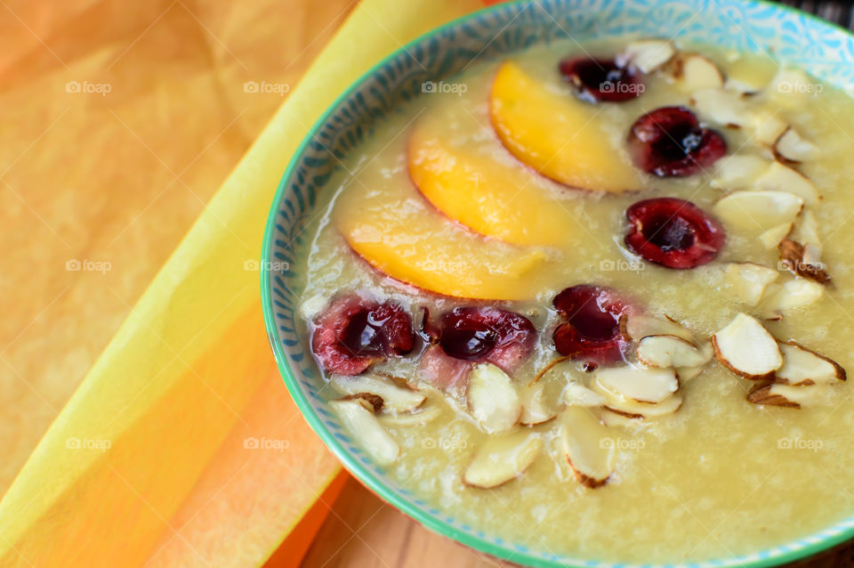 Cherries, peaches and almonds in coconut white fruit smoothie bowl conceptual healthy eating and healthy meals and nutrition summer time food photography 