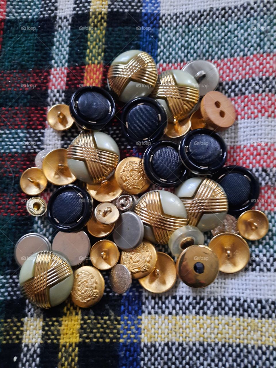 pile of colorful buttons on woolen fabric