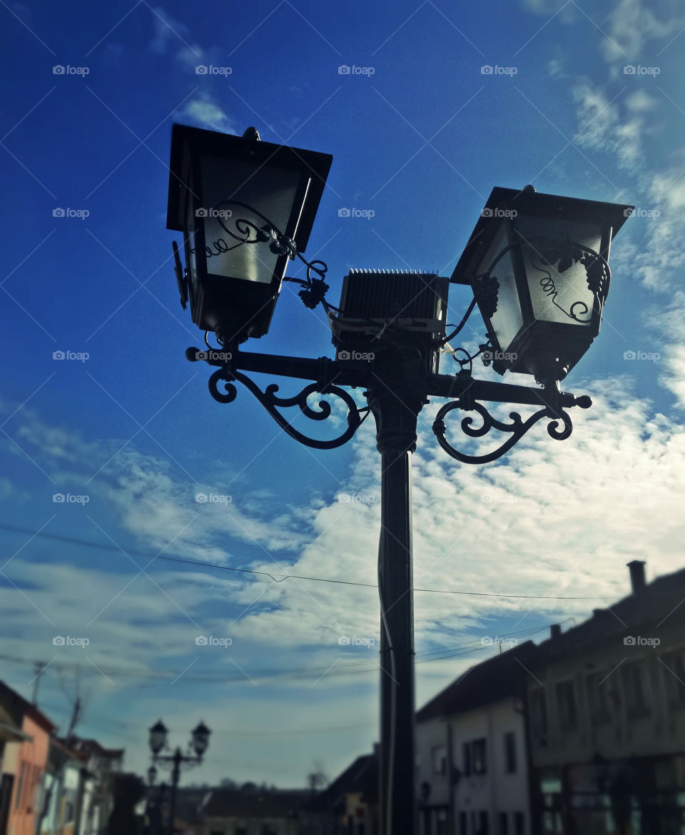 street lamp, city and blue sky with clouds